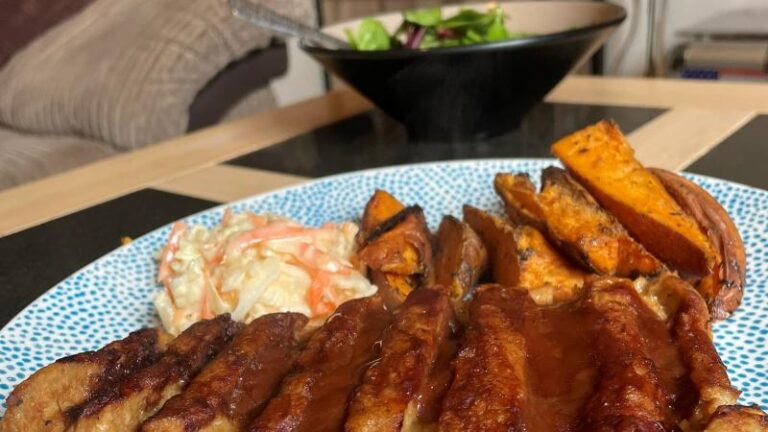 Close-up of ASDA OMV BBQ No Ribs with wedges and coleslaw on a plate