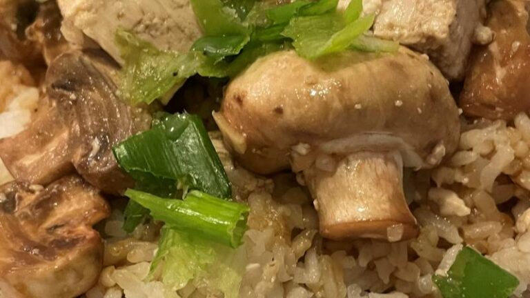 Very close-up of button mushroom, tofu, spring onion and garlic sesame rice