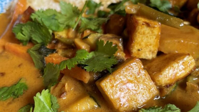 Close-up of creamy tofu korma with mushrooms, courgette and fresh coriander