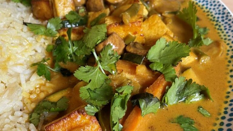 Close-up of creamy tofu korma with fresh coriander and cardamom butter rice