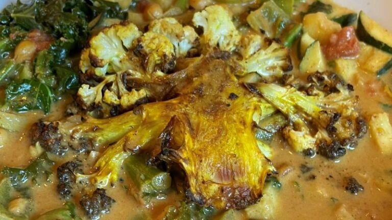 Close-up of crispy cauliflower steaks in creamy coconut curry sauce