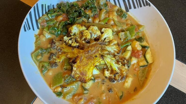 Homemade crispy cauliflower steaks in a creamy coconut curry sauce with vegetables