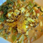 Crispy cauliflower steaks with chickpeas, kale, courgette and creamy coconut curry sauce