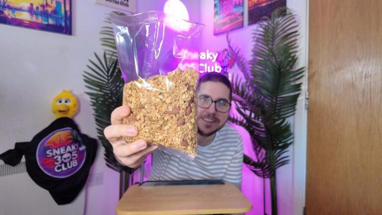 Ian showing the bag of Deliciously Ella Almond Butter Protein Granola to the camera