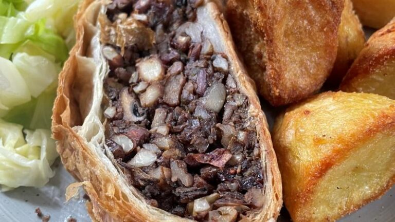 Close-up of vegan mushroom and chestnut Wellington with roast potatoes at Donkey and Buskins near Colchester