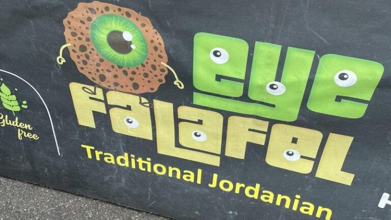 Close-up shot of the Eye Falafel logo displayed on a cover outside the stall in London