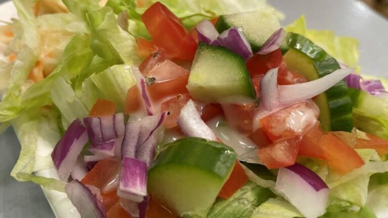 Side salad with lettuce, tomato, cucumber, red onion and coleslaw at Hanks Dirty in Colchester
