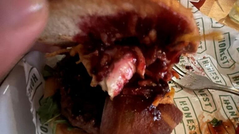 Inside view of the Honest Burgers Camembert Beyond Christmas Burger showing vegan Shamembert and cranberry sauce