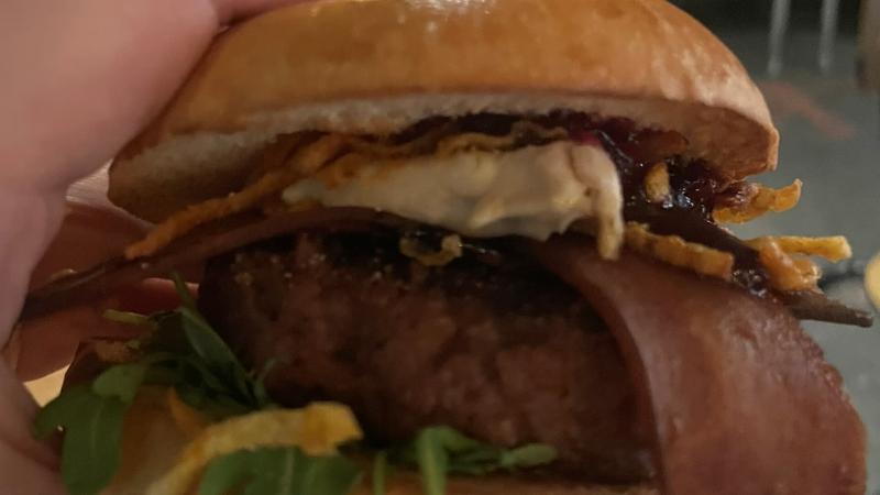 Close-up of the Honest Burgers Camembert Beyond Christmas Burger with vegan Shamembert and cranberry sauce