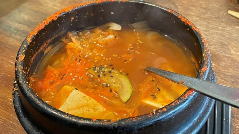 Full-size shot looking into the tofu Kimchi Jjigae at Kimchi House in Colchester, boiling hot with bits of steam visible