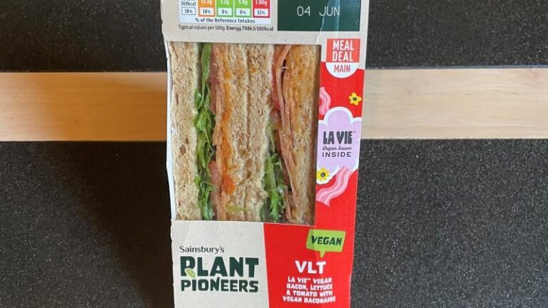 Close-up shot of a La Vie vegan VLT sandwich in its wrapper on a table
