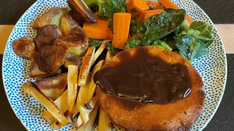 Magpye and Honestly Tasty Steak and Blue Cheese Pie topped with gravy, served with chips and vegetables