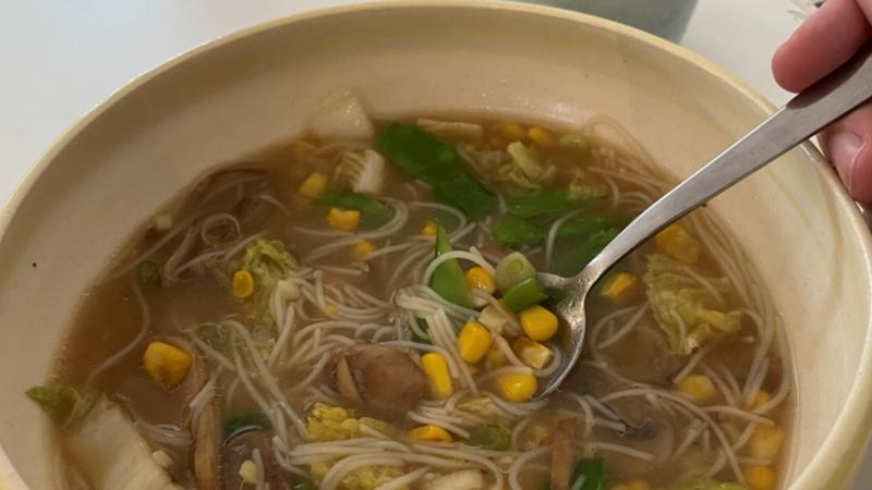 Close-up of miso sweetcorn chowder with a spoon in the bowl at The Commons Cafe in Colchester