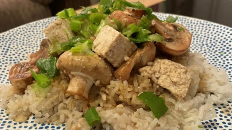Close-up plate shot of steamed button mushrooms and tofu with garlic sesame rice