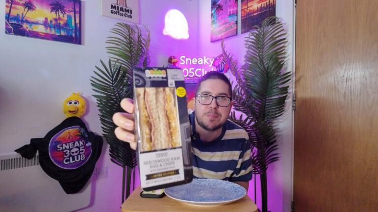 Ian holding the packaged Tesco Beechwood Ham Egg and Chips Sandwich to the camera