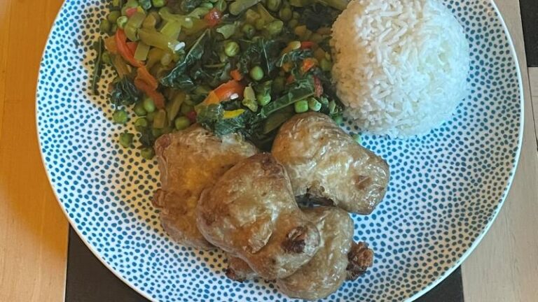 Cooked THIS Isn’t vegan chicken thighs on a plate with peas, kale, peppers and rice