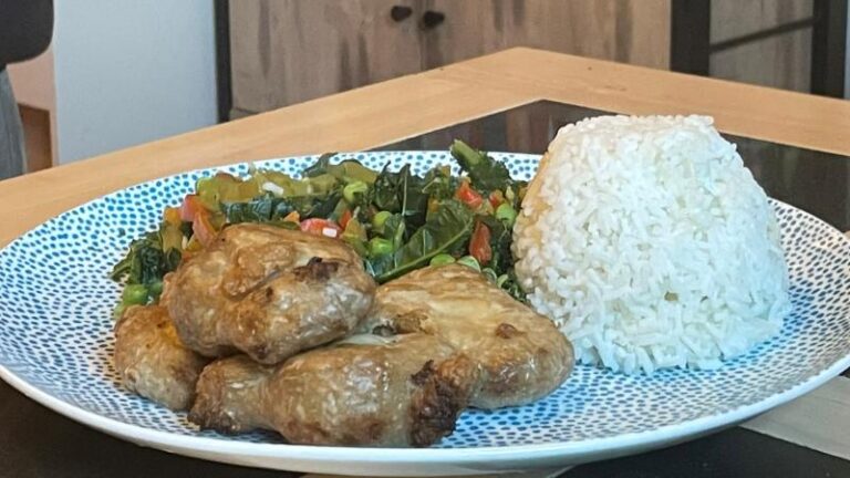 Full plate shot of cooked THIS Isn’t vegan chicken thighs with peas, kale, peppers and rice