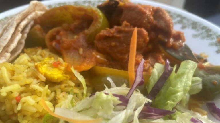 Close-up of Jomidar Mahal Lahori lamb curry with rice and salad