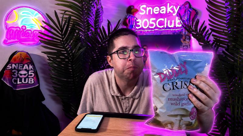 Ian taste testing Diddly Squat Farm Mushroom and Wild Garlic Crisps while holding the bag