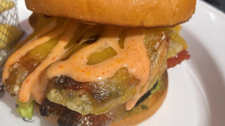 Close-up of the Vegan Dirty Brunch Burger at The Swan in Chappel with vegan cheese, sauce and pickles
