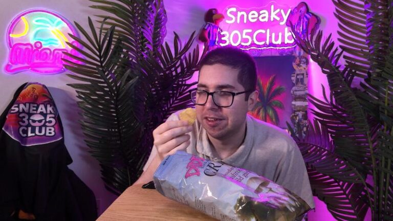 Ian holding a Diddly Squat Farm Mushroom and Wild Garlic crisp while reviewing the flavour